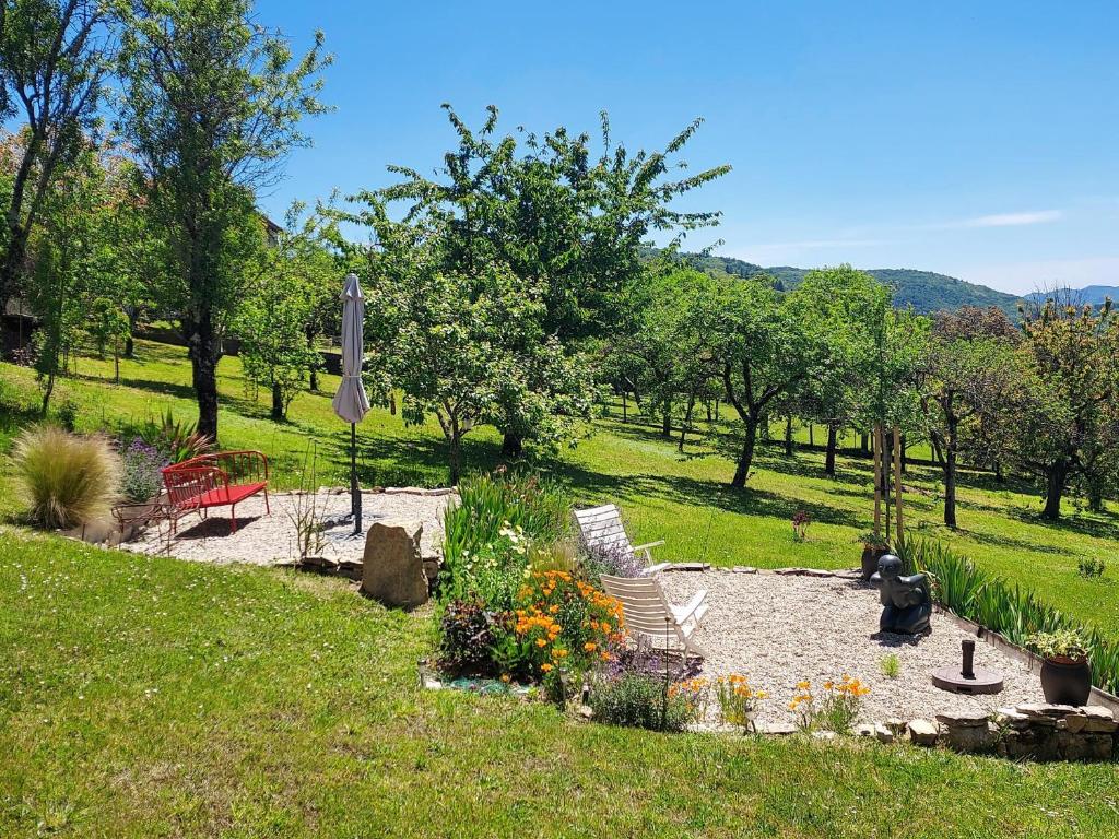 - un jardin avec des chaises et des fleurs dans un parc dans l'établissement Les Iris, à Villefranche-de-Rouergue