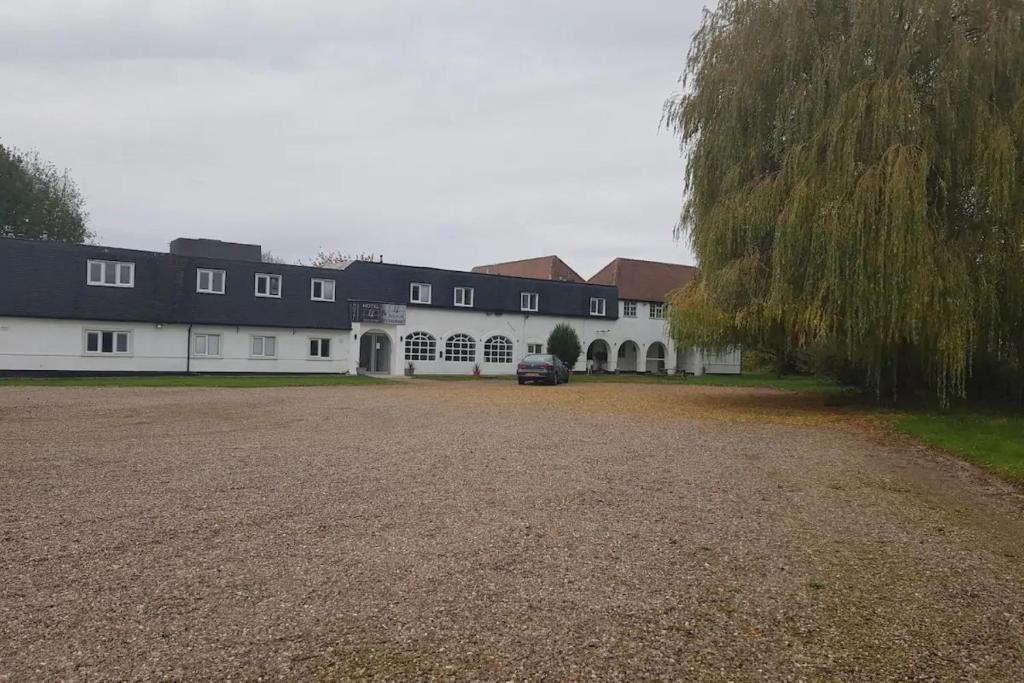 a large white building with a black roof at OYO Belvoir Hotel in Nottingham