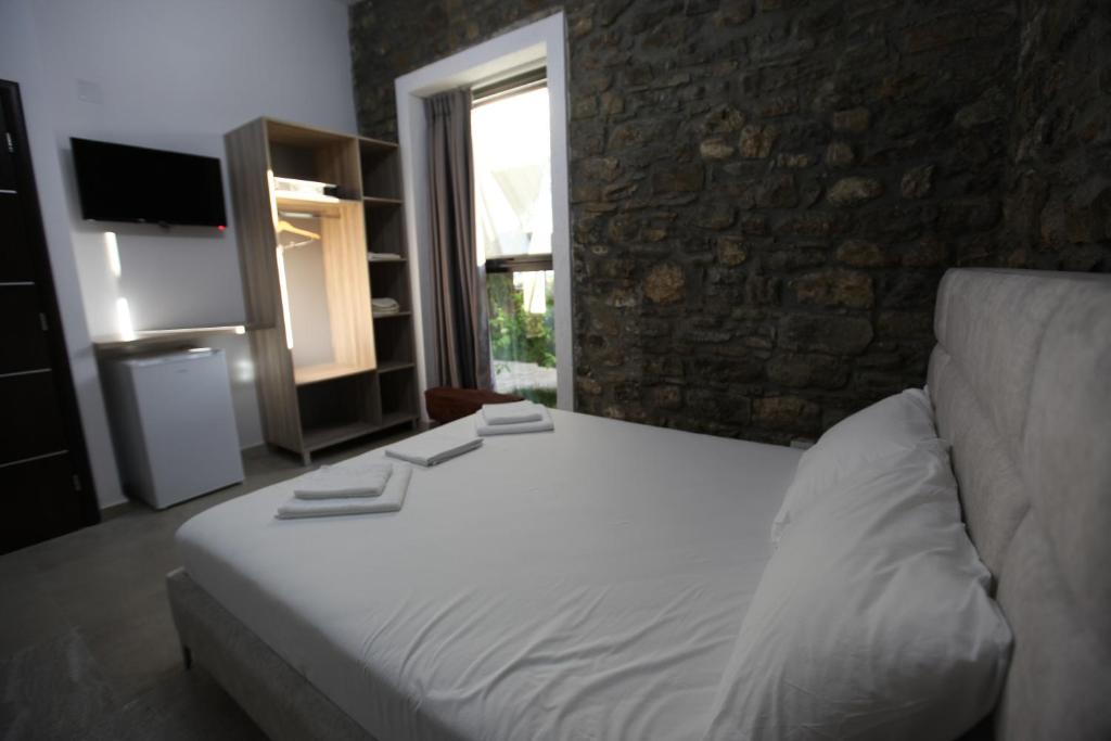 a bedroom with a white bed and a couch at Bunec Beach Resort in Piqeras