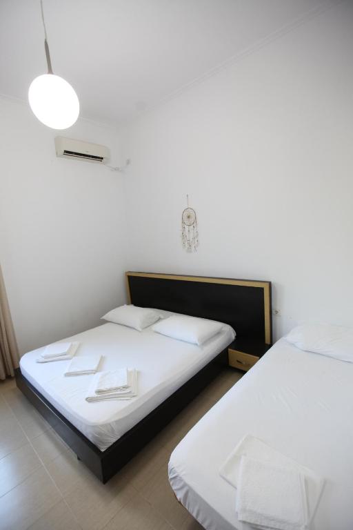 two beds in a room with white walls at Bunec Beach Resort in Piqeras