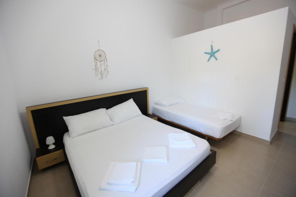 a bedroom with two beds with white sheets at Bunec Beach Resort in Piqeras
