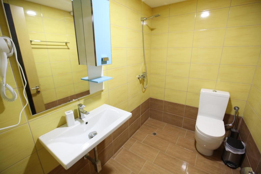 a bathroom with a sink and a toilet and a mirror at Bunec Beach Resort in Piqeras