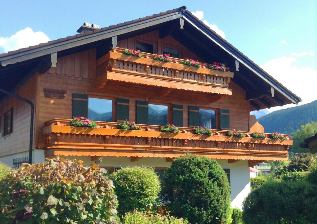 une maison avec un balcon fleuri dans l'établissement Ferienwohnung Aigner, à Bischofswiesen