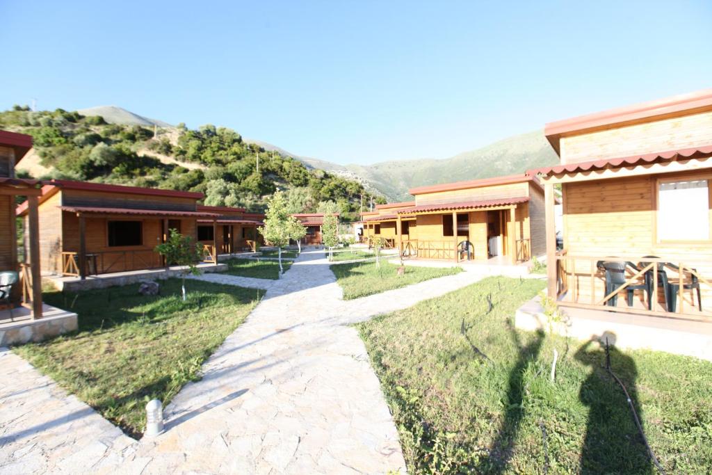a path between two buildings with mountains in the background at Bunec Beach Resort in Piqeras