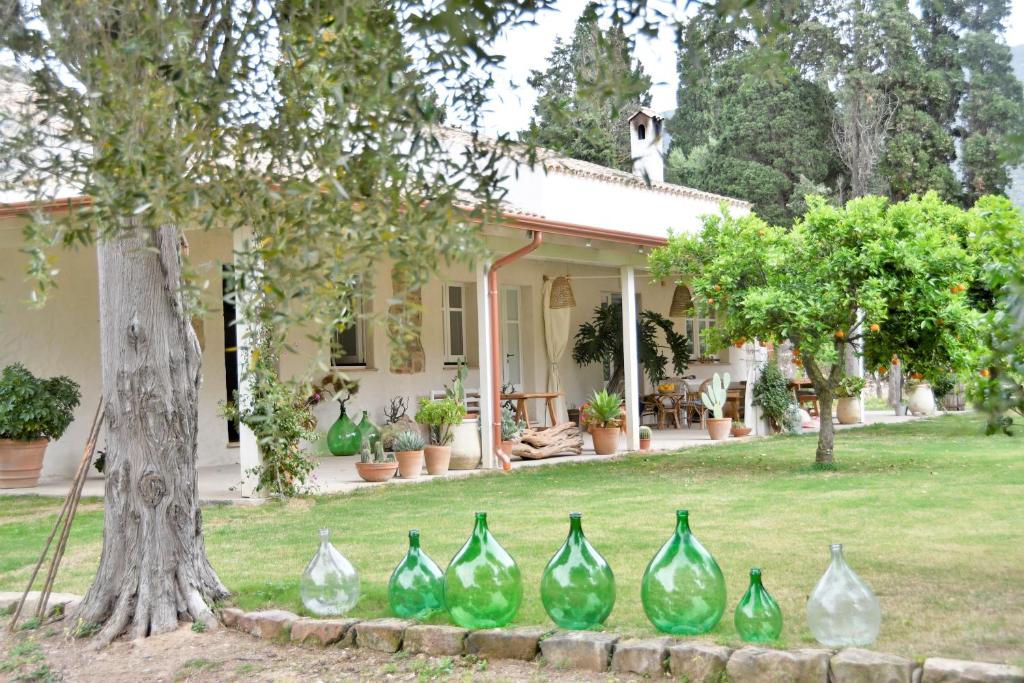 un grupo de jarrones de cristal verde frente a una casa en B&B Giallo Limone, en Teulada