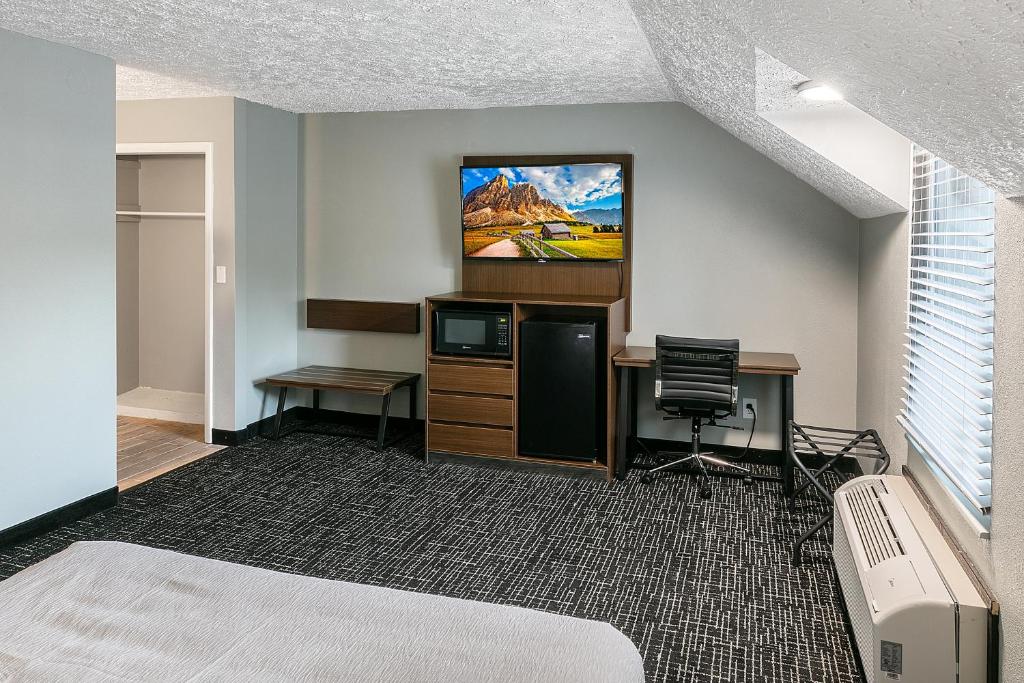 a hotel room with a bed and a desk and a tv at Gatlinburg Mountain Inn in Gatlinburg