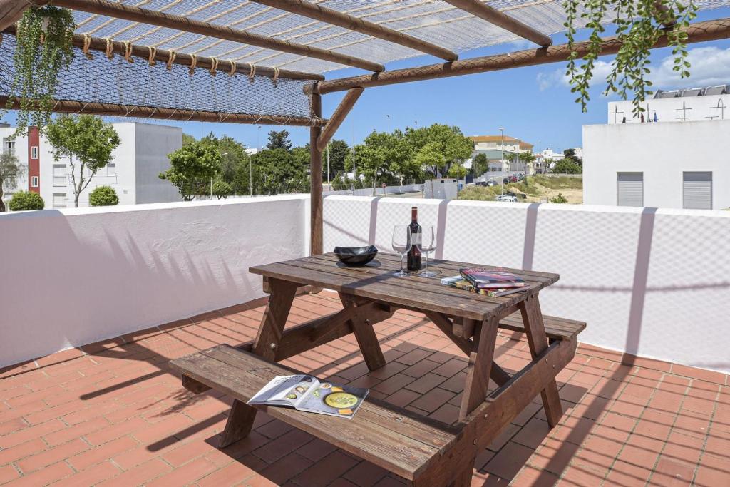 科尼爾－德拉弗龍特拉的住宿－Casa Ainhoa，天井上的野餐桌和一瓶葡萄酒