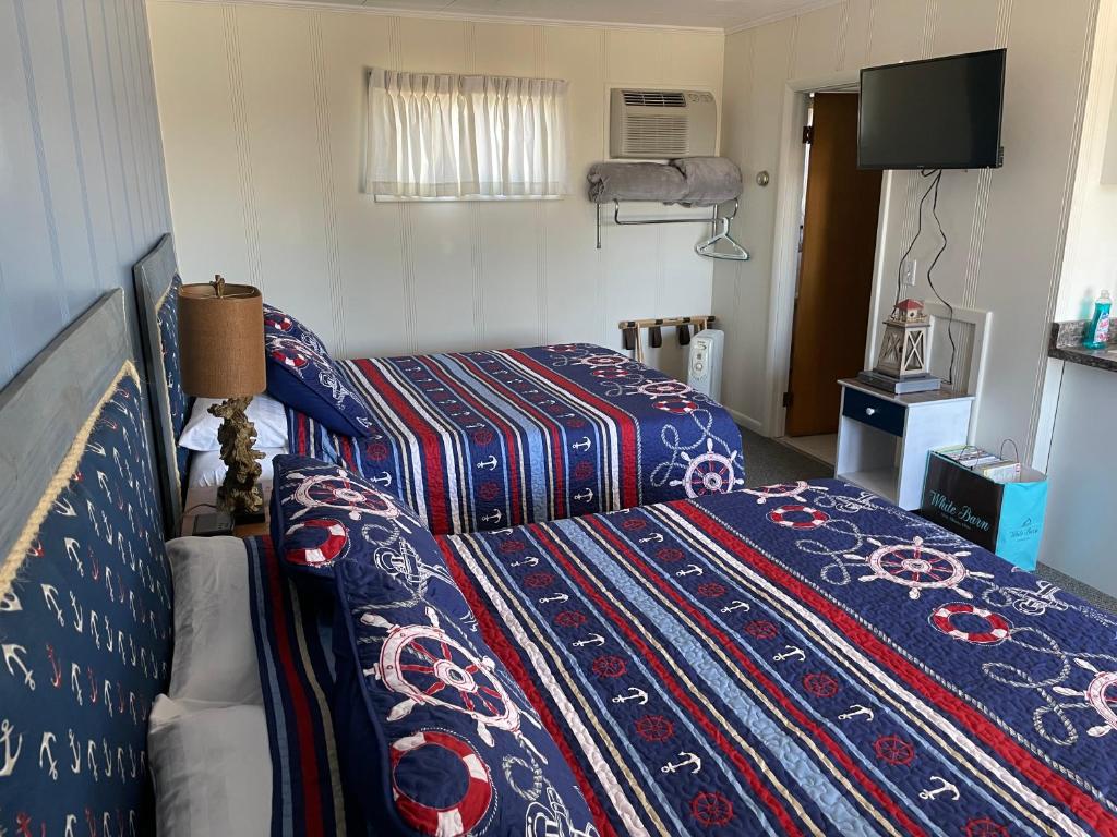 Habitación de hotel con 2 camas y TV en Pure Paradise Resort en Carp Lake