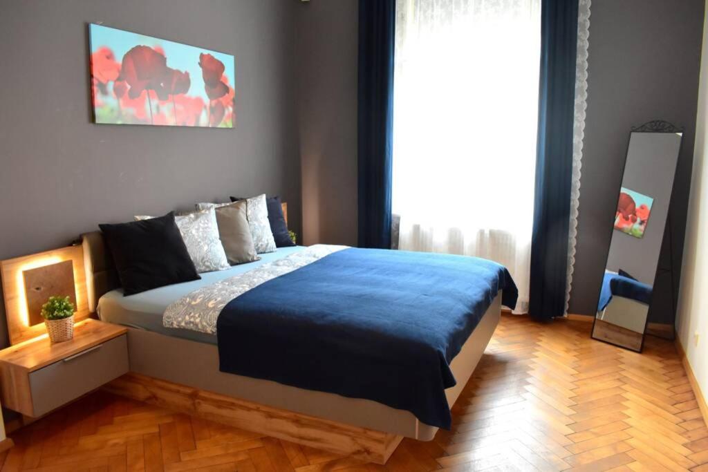 um quarto com uma cama grande e um cobertor azul em Airstay Prague : DeLuxe Apartment Old town em Praga