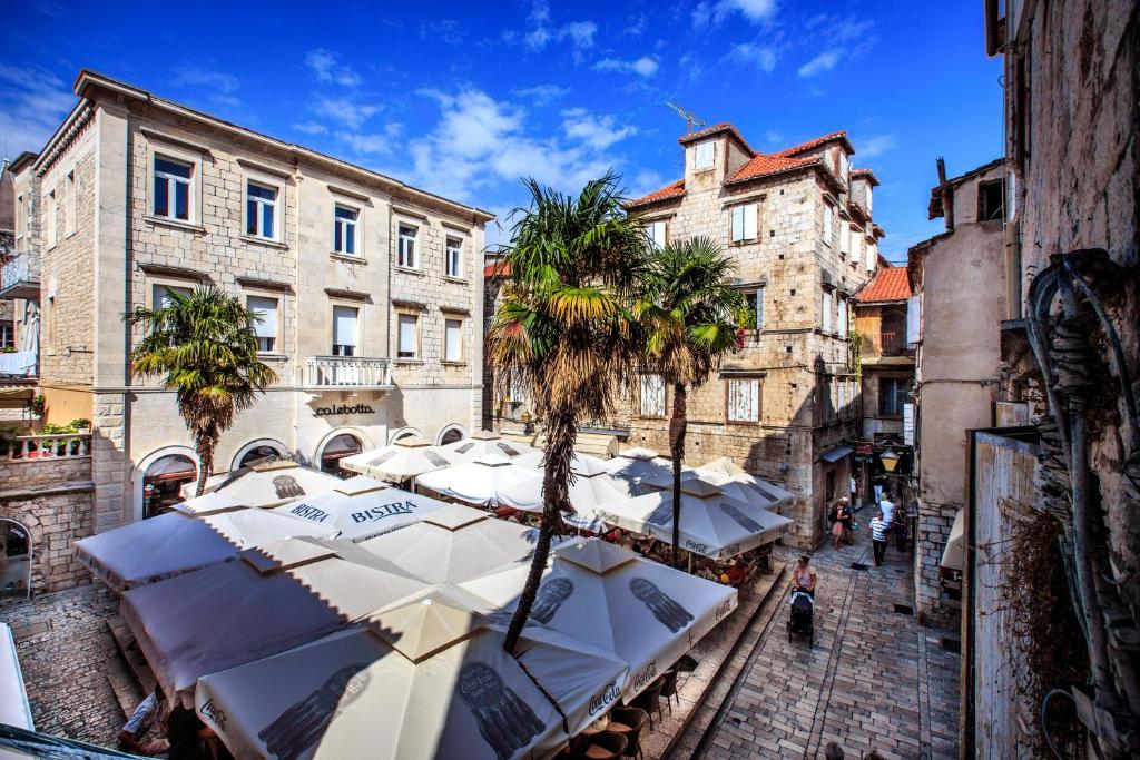 a group of umbrellas in a street with buildings at Trogir Old Town Residence in Trogir