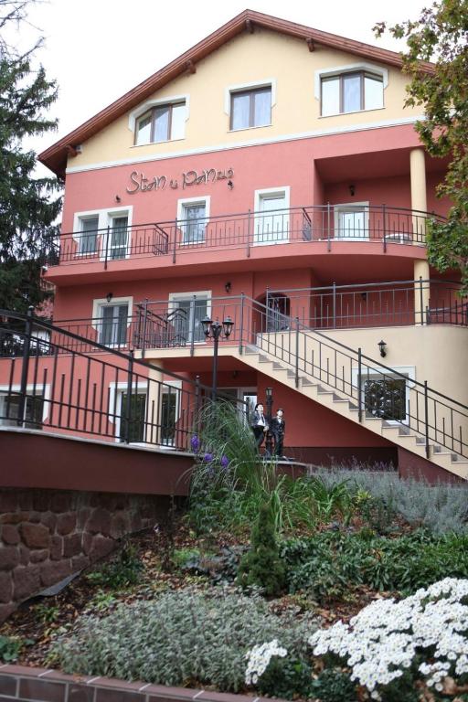 a red building with flowers in front of it at Stan és Panzió in Balatonalmádi