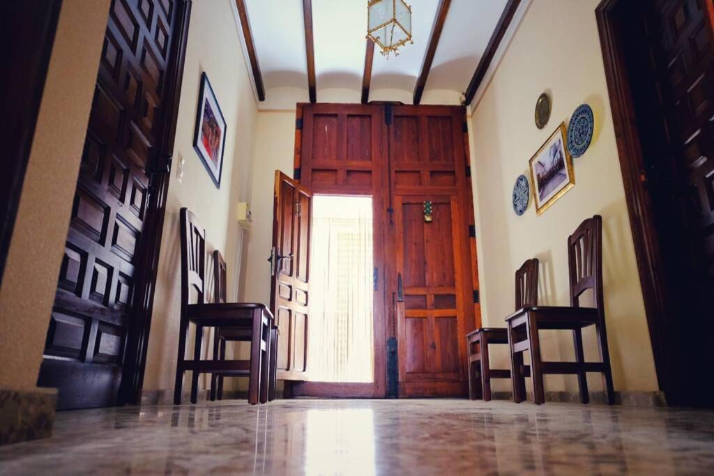un pasillo con una gran puerta de madera y 2 sillas en Casa rural “Ca Robert”, en Callosa de Ensarriá