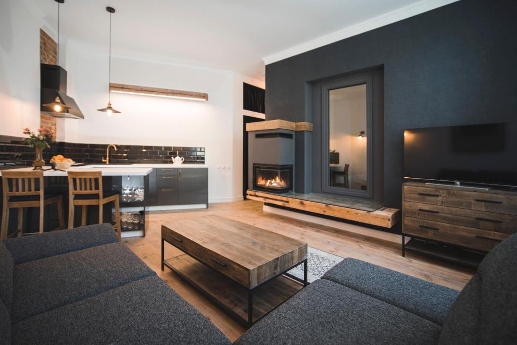 a living room with a couch and a fireplace at Berchy Apartment 1 in Liepāja