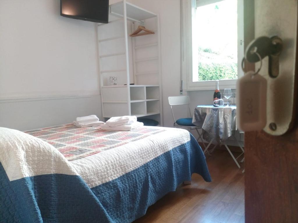 a bedroom with a bed and a table and a window at The Lake Room in Garda