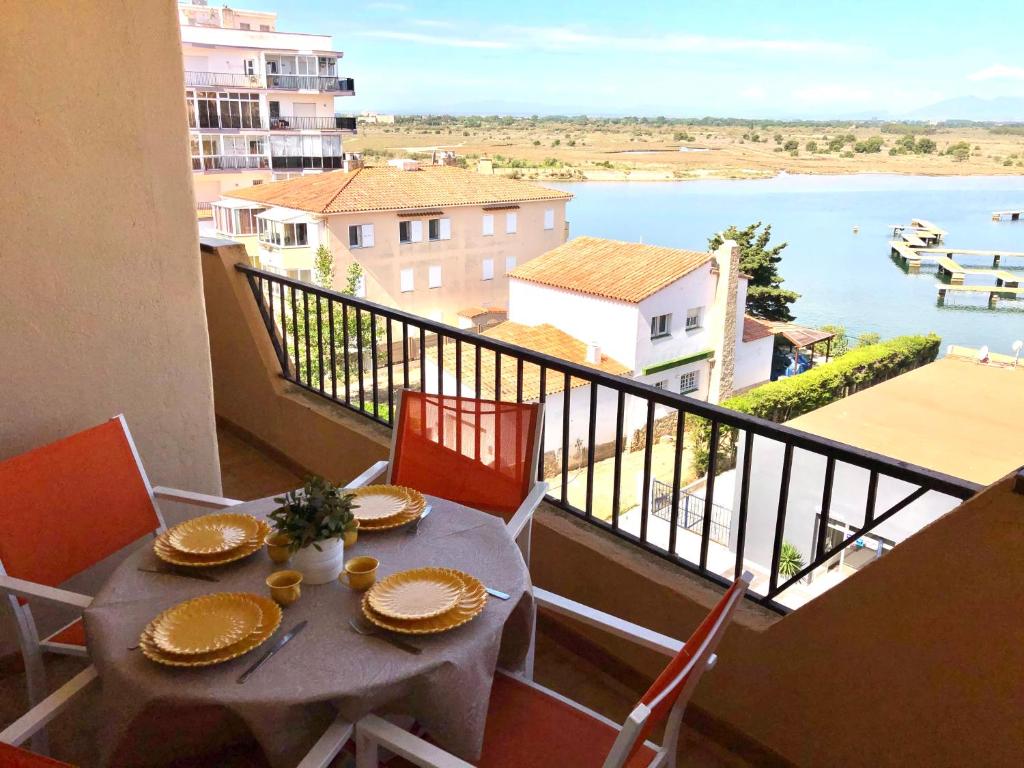 un tavolo su un balcone con vista sull'acqua di ROMINA 4E - Apartamento en los canales de Roses Santa Margarita - terraza con vistas a Roses