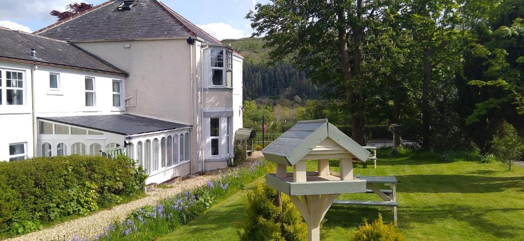 uma casa de pássaros em frente a uma casa branca em Link House em Bassenthwaite Lake