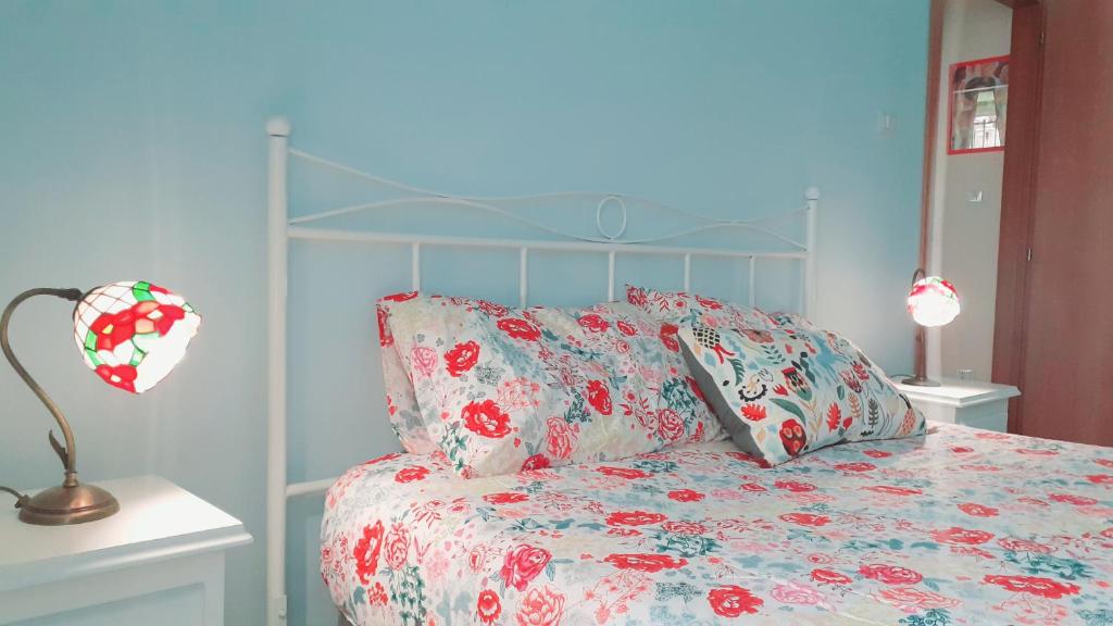 a bedroom with a bed with a floral bedspread at Casa Vacanze "Donna Manu', tra Stazione Centrale, Metro e Aeroporto TURISMO CULTURALE in Naples