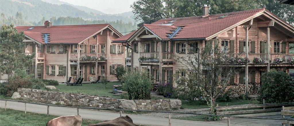 a large wooden house with a fence in front of it at Quartier360Grad in Bolsterlang