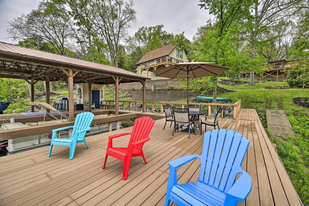 a deck with chairs and tables and an umbrella at Lake House Haven Fire Pit, Boat Dock and More! in Watauga
