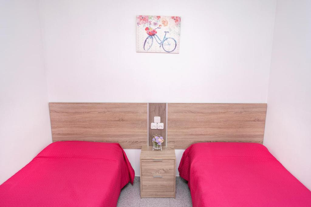 2 camas en una habitación con sábanas rosas en Lorena, en Salou