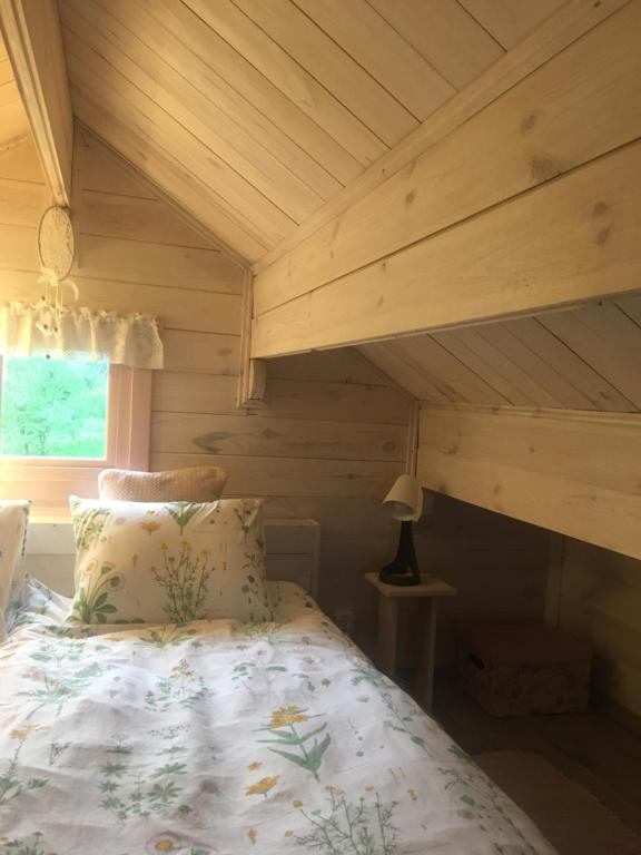 a bed in a room with a wooden ceiling at 83 Bredynki in Biskupiec