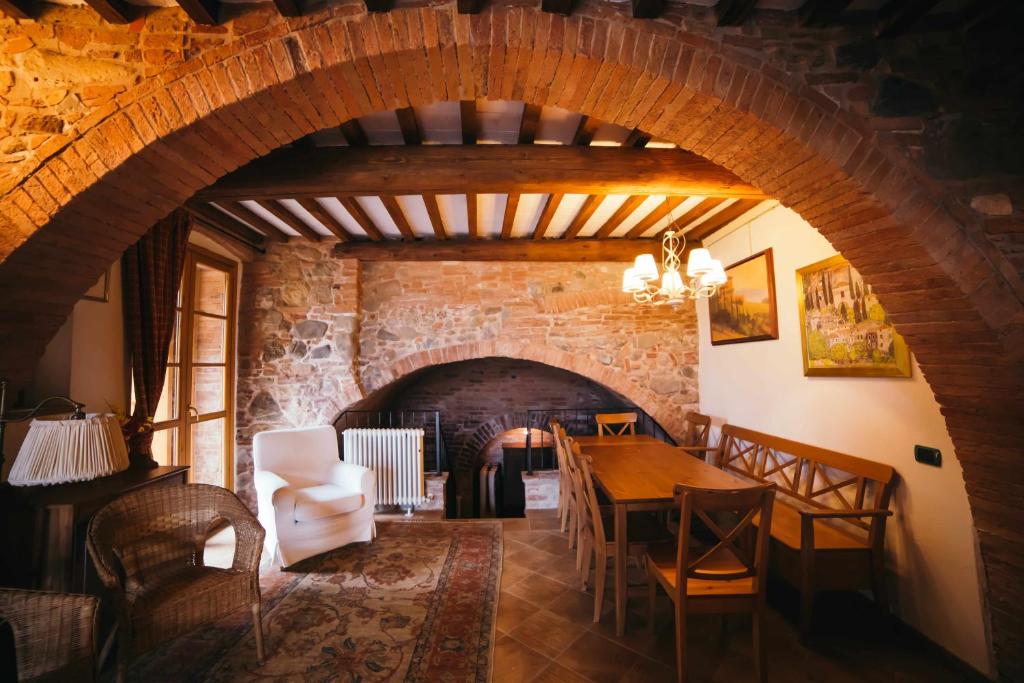 a dining room with an archway and a table and chairs at Borgo 7 TigliAppartamento a Montepulciano n1 in Montepulciano