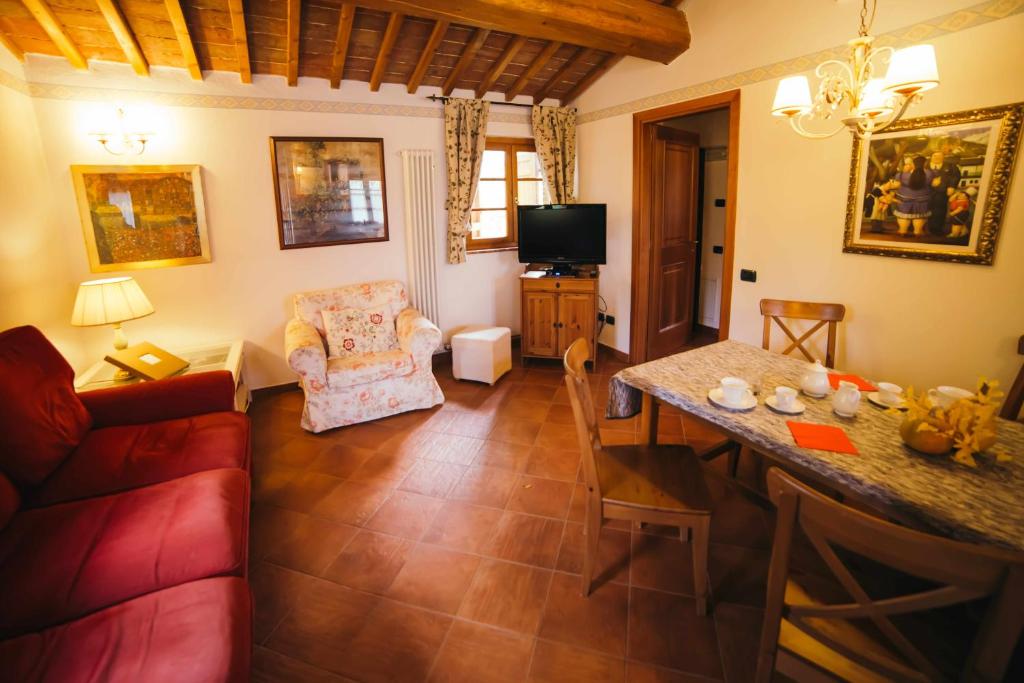 a living room with a red couch and a table at Borgo 7 TigliAppartamento a Montepulciano n7 in Montepulciano