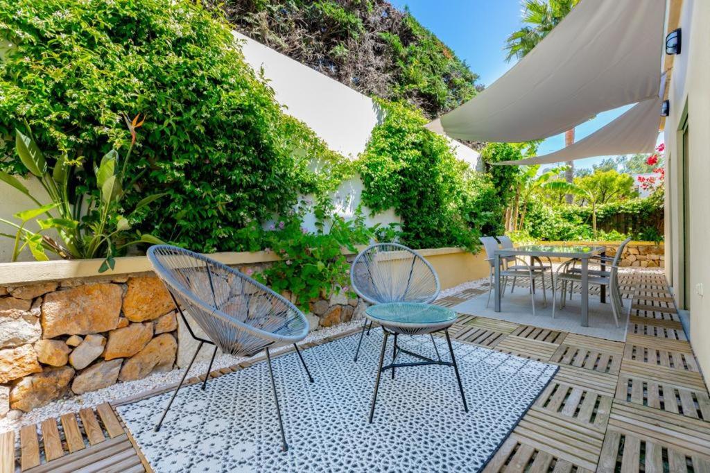 patio z krzesłami i stołami oraz kamienną ścianą w obiekcie AB Cap French Riviera - Cap d'Antibes w mieście Antibes