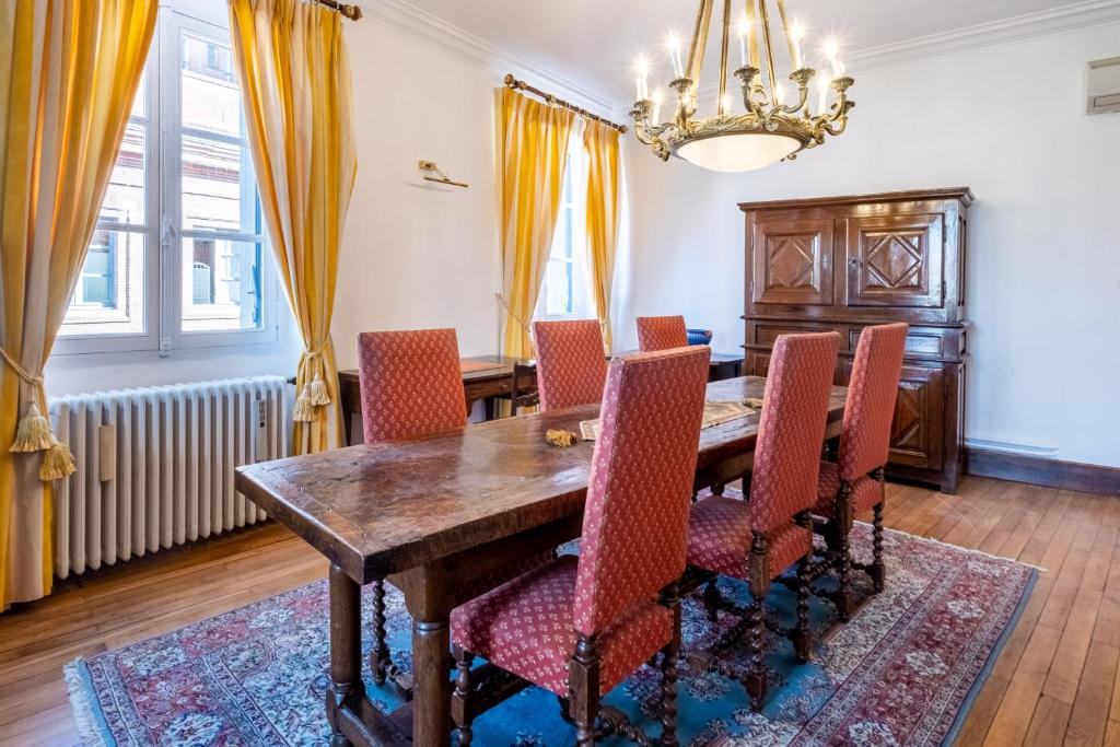 une salle à manger avec une table et des chaises en bois dans l'établissement NOCNOC - Le Napoleon, 200m2 au cœur de Toulouse, à Toulouse