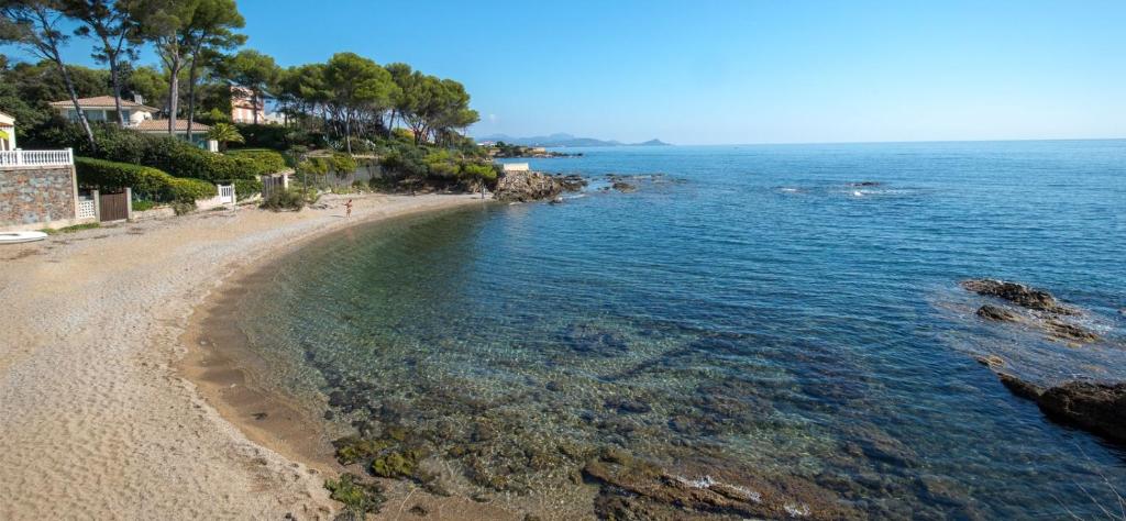 - une vue sur la plage avec des rochers et l'eau dans l'établissement Charmante petite maison à St Aygulf, à Saint-Aygulf