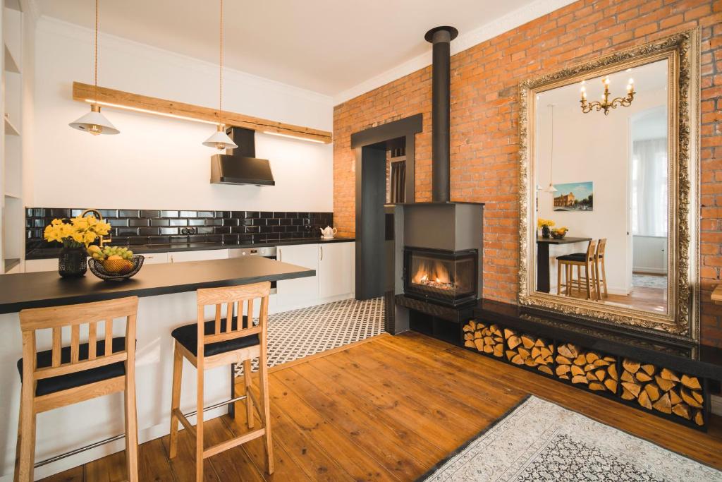 a kitchen with a brick wall and a fireplace at Berchy Apartment 3 in Liepāja