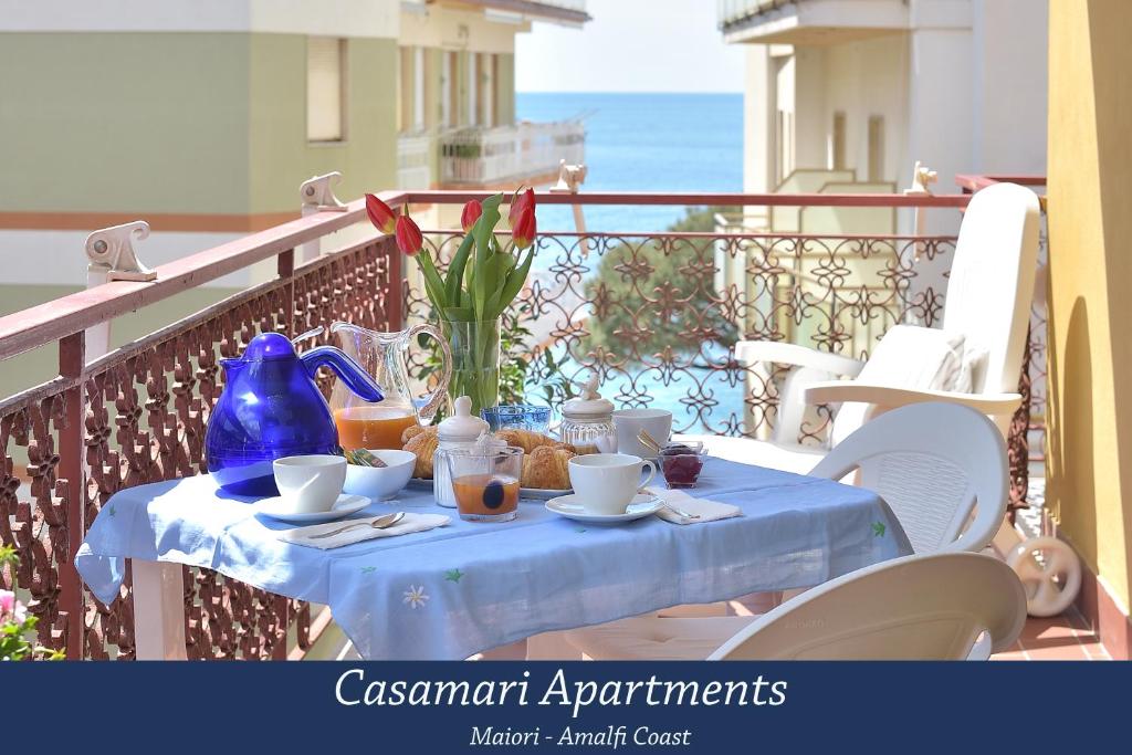 Casamari Apartments في مايوري: طاولة مع قماش الطاولة الزرقاء على شرفة
