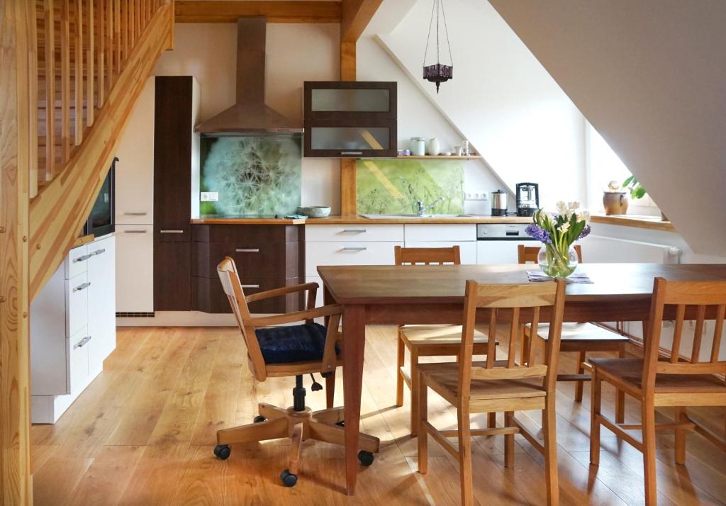 a kitchen with a wooden table and wooden chairs at Gästehaus Kibbel in Bosau