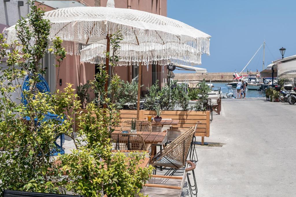 a table and chairs under an umbrella on a sidewalk at Aisha Petite Suites in Chania