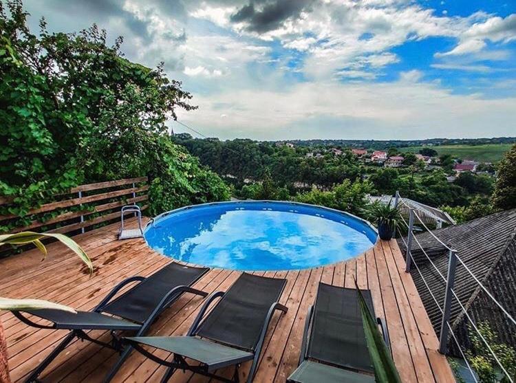 a deck with two chairs and a swimming pool at Tatsopus in Kamianets-Podilskyi