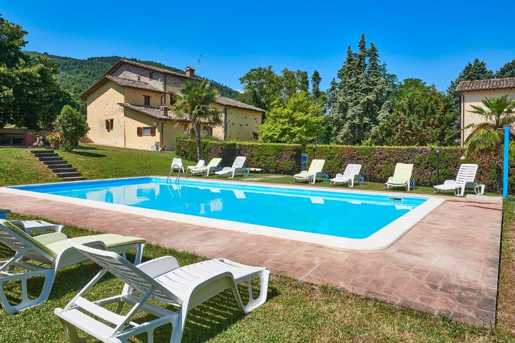 uma piscina com espreguiçadeiras e uma casa em La Rosa em Città di Castello