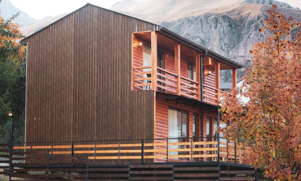 una casa de madera con una montaña en el fondo en My Space Kazbegi, en Kazbegi