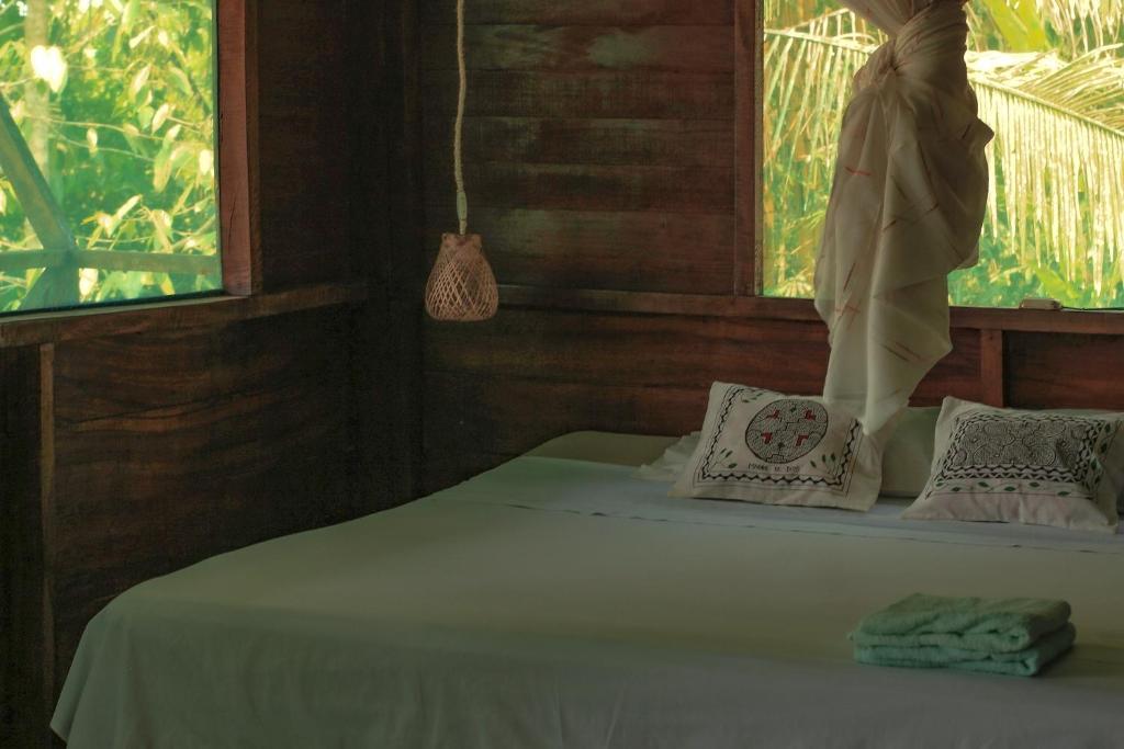 uma cama num quarto de madeira com uma janela em K'erenda Homet Reserva Natural em Puerto Maldonado