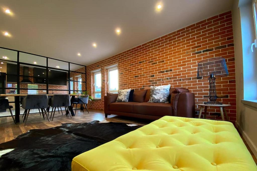 a living room with a couch and a brick wall at Fátima Host 3AP6 in Fátima