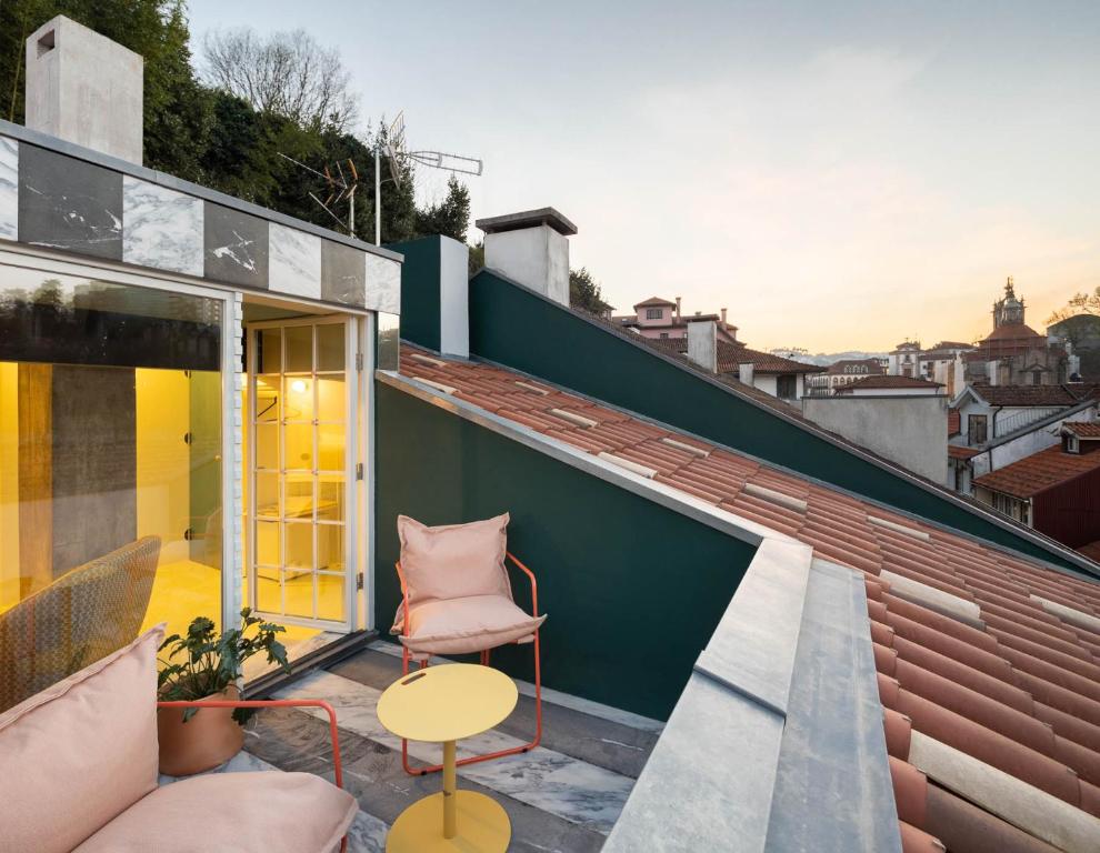 een patio met een stoel en een tafel op een dak bij Covelo - The Original Rooms and Suites in Amarante