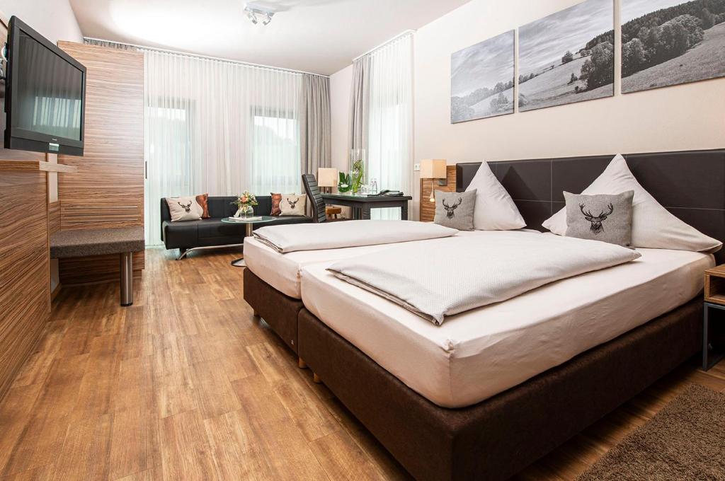 1 dormitorio con 1 cama grande y sala de estar en Müller´s Landhotel, en Mespelbrunn