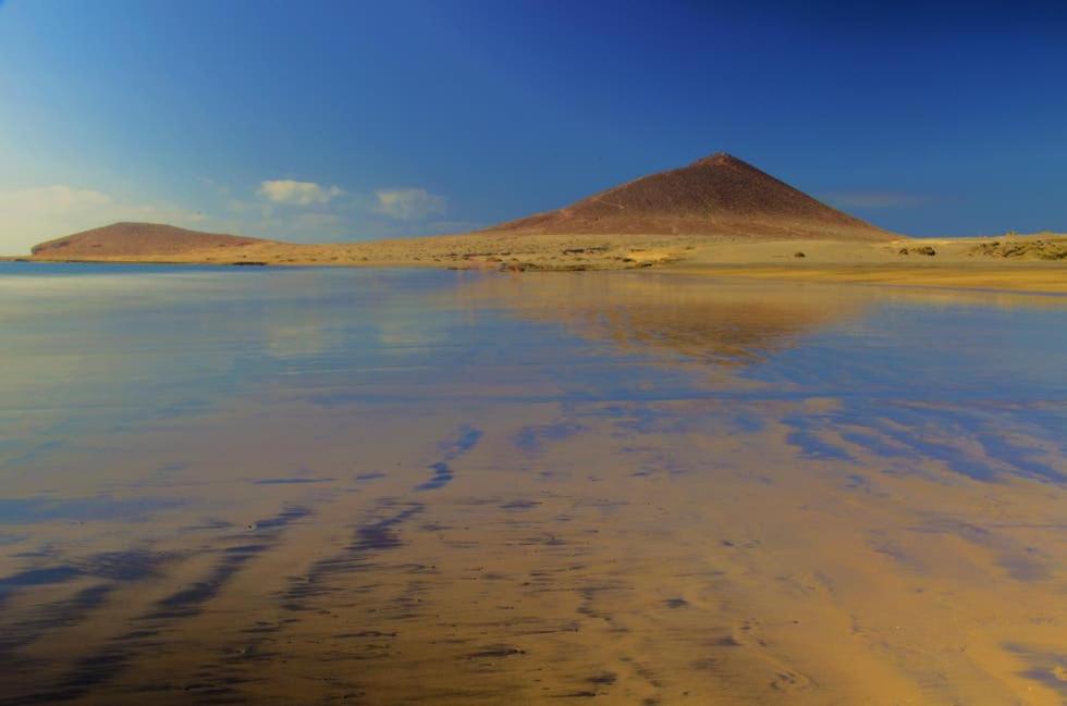 - une vue sur une plage avec une pyramide en arrière-plan dans l'établissement PARAISO DEL MEDANO ,CENTRICO, à El Médano