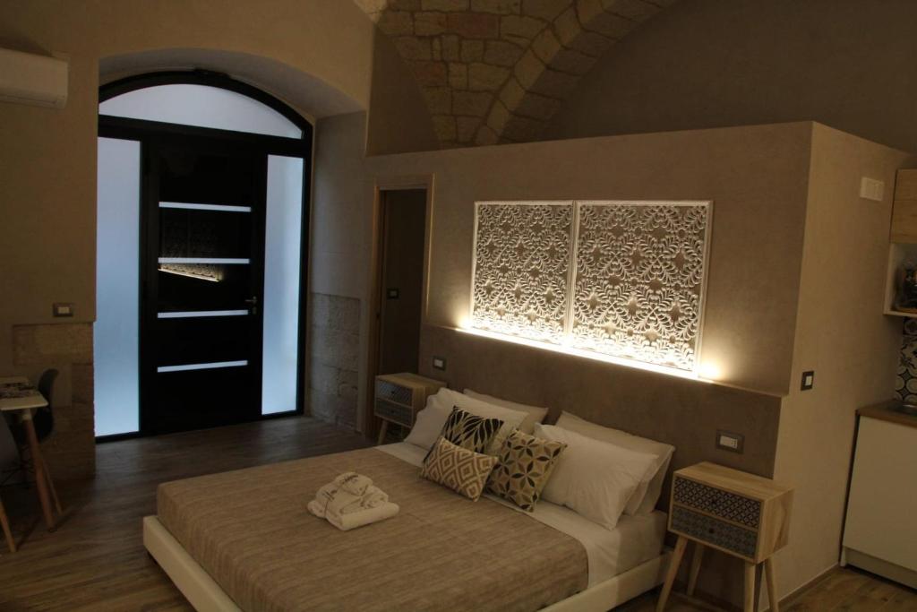 a bedroom with a bed with a light on the wall at LA DIMORA DEL PRINCIPE-Loft in Trani