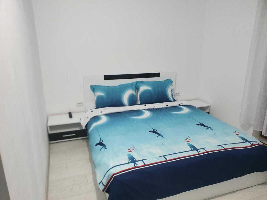 um quarto com uma cama com um edredão azul em Casa Simionov em Băile Herculane