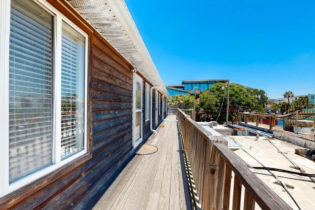 un porche de madera de una casa con ventana en Folly Beach Condos, en Folly Beach
