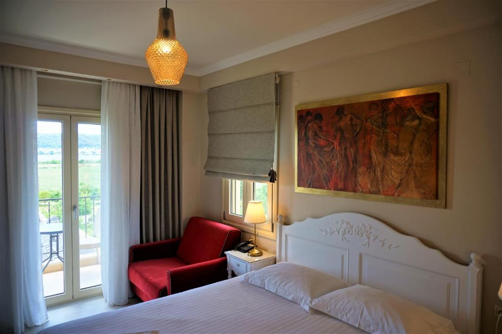 um quarto com uma cama e uma cadeira vermelha em Anemolia Resort and Spa em Ioannina