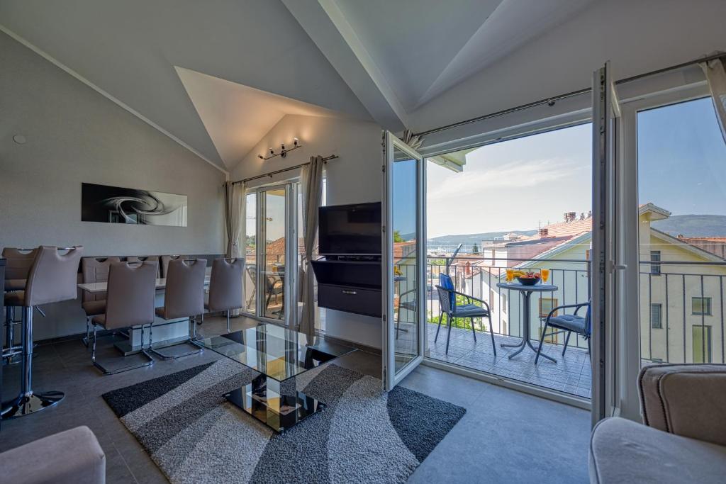 a living room with a view of a balcony at Porto View Three-Bedroom Duplex in Tivat