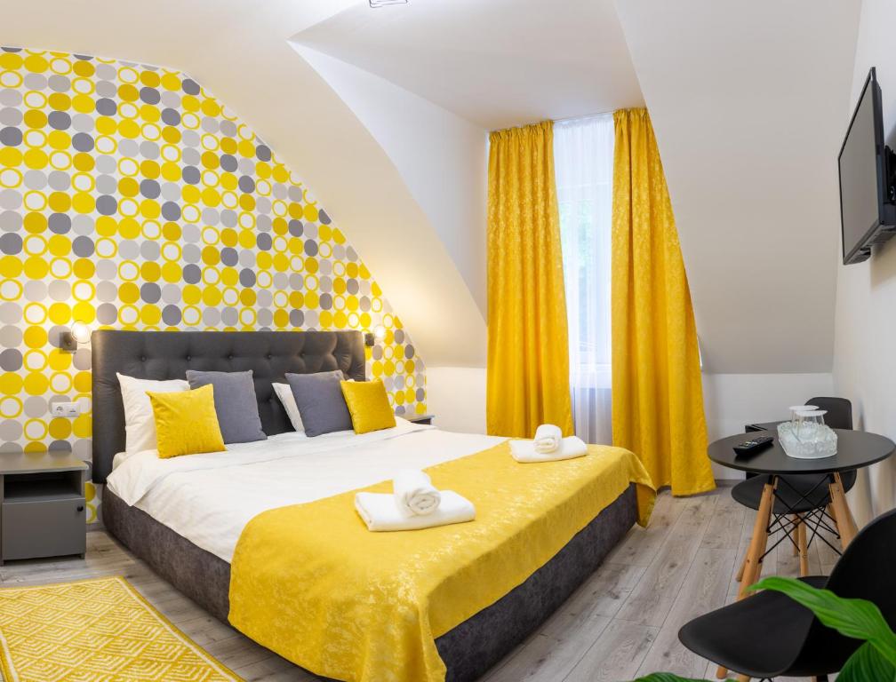 Hotel Amel Rooms في ميدياس: غرفة نوم بسرير كبير مع اللوح الأمامي الأصفر