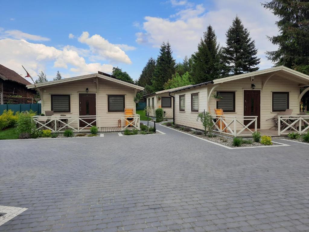 a couple of buildings with a parking lot at Domki przy jeziorze Wejsuny in Ruciane-Nida