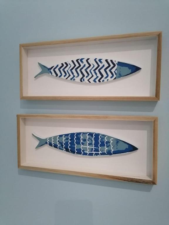 two fish canvases in wooden frames on a wall at Hotel Marisma Sancti Petri in Chiclana de la Frontera